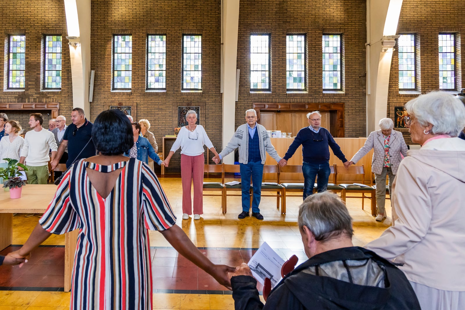 Laywoman Marijke Devaddere, center left, and Rik Deville, a retired priest, center right, together with other parishioners participate in a service at the Don Bosco church in Buizingen, Belgium, Sunday, Sept. 8, 2024. (AP Photo/Geert Vanden Wijngaert)