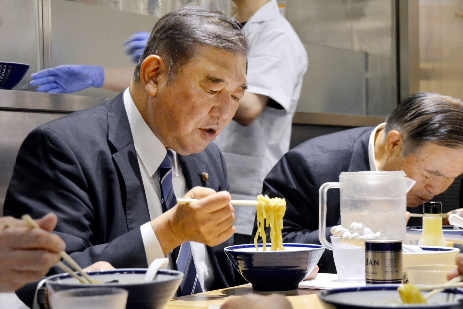 Shigeru Ishiba and other LDP members eat a bowl of ramen noodles at a ramen shop in Tokyo, May 21, 2024. (Kyodo News via AP)