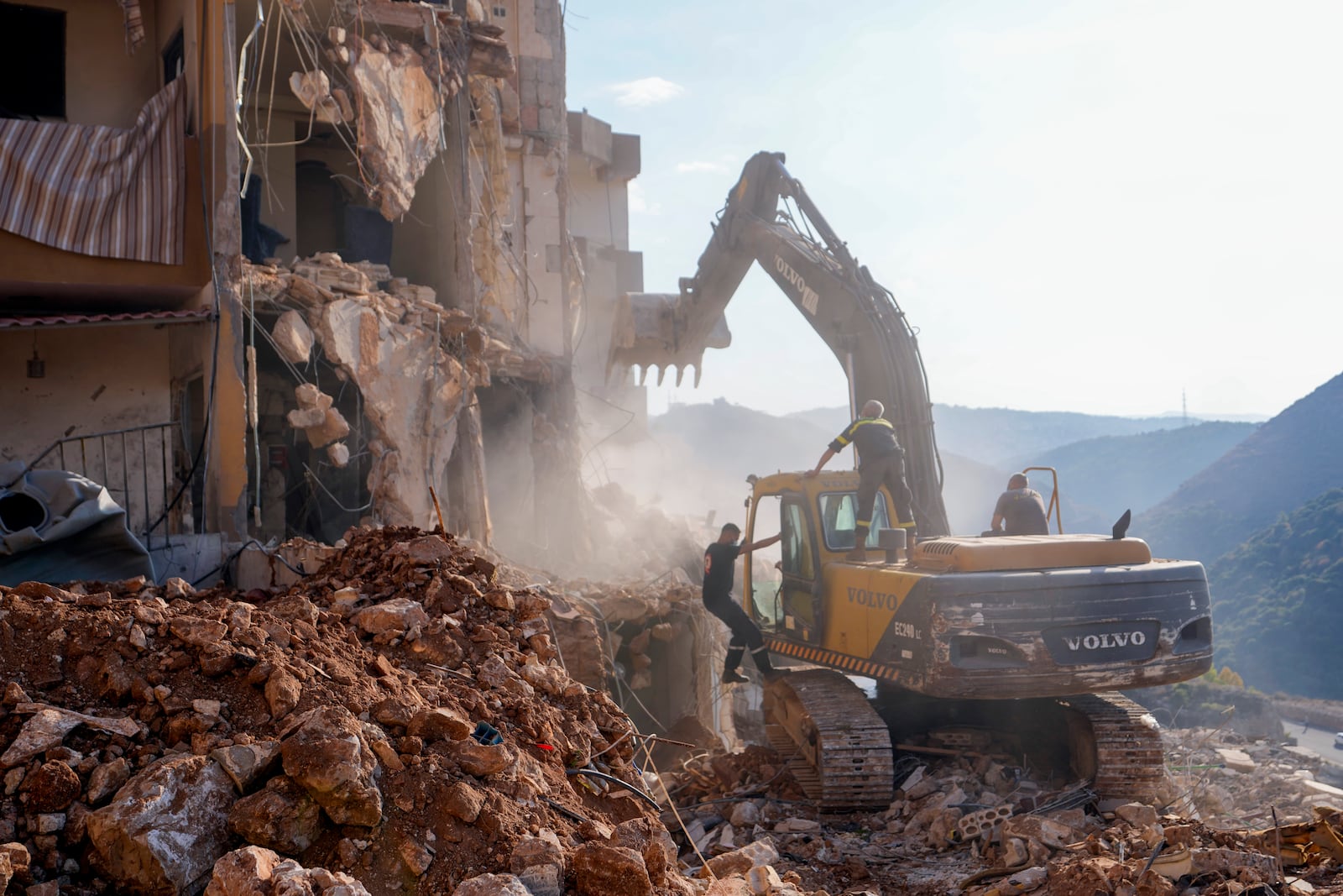 Rescue workers use excavators to remove the rubble of a destroyed building that was hit Tuesday night in an Israeli airstrike, as they search for victims in Barja, Lebanon, Wednesday, Nov. 6, 2024. (AP Photo/Hassan Ammar)