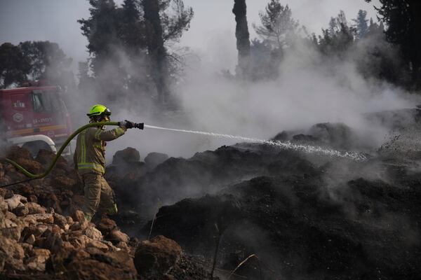 An Israeli firefighter battles a wildfire near Latrun, Israel, outside of Jerusalem, Thursday, May 1, 2025. (AP Photo/Ohad Zwigenberg)