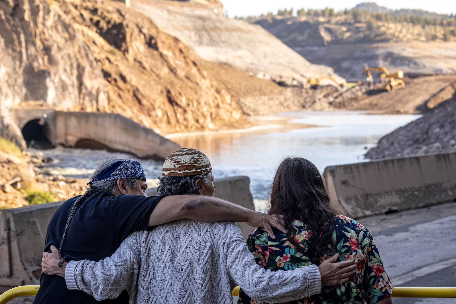 FILE - The Hillman family, from left, Leaf, Lisa, and Chaas, hug as construction crews removed the final cofferdam that was left of Iron Gate Dam allowing the Klamath River to run freely near Hornbrook, Calif., Aug. 28, 2024. (Carlos Avila Gonzalez/San Francisco Chronicle via AP, File)