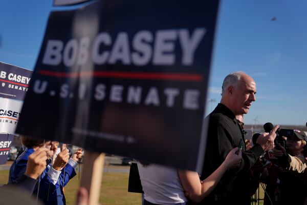 Sen. Bob Casey, D-Pa., left, stops to speak to members of the media before voting, Tuesday, Nov. 5, 2024, in Scranton, Pa. (AP Photo/Matt Rourke)