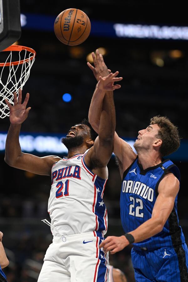 Philadelphia 76ers center Joel Embiid (21) is fouled by Orlando Magic forward Franz Wagner (22) while going up to shoot during the first half of an Emirates NBA Cup basketball game, Friday, Nov. 15, 2024, in Orlando, Fla. (AP Photo/Phelan M. Ebenhack)