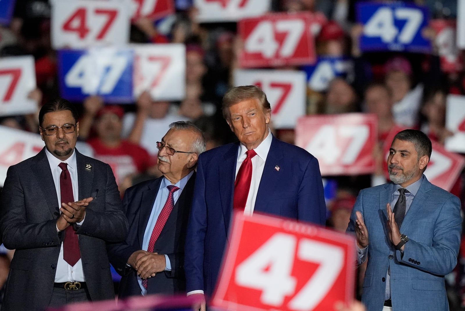 Republican presidential nominee former President Donald Trump, second from right, stands alongside local Muslim leaders during a campaign rally at the Suburban Collection Showplace, Saturday, Oct. 26, 2024 in Novi, Mich. (AP Photo/Carlos Osorio)