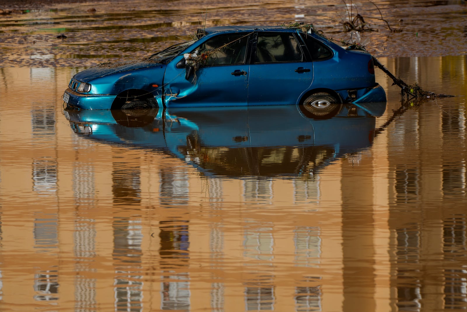 A flooded car is reflected in the water in Utiel, Spain, Wednesday, Oct. 30, 2024. (AP Photo/Manu Fernandez)