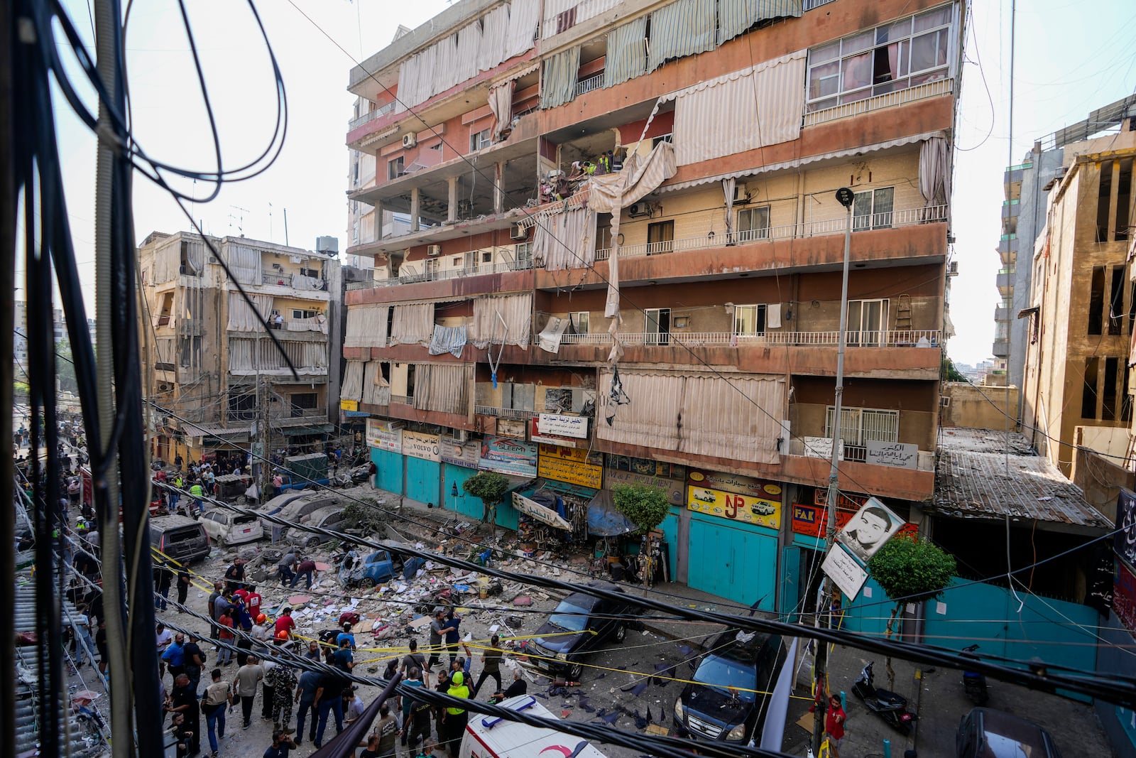 Residents and rescuers check a building that was hit by an Israeli airstrike in Beirut's southern suburbs, Tuesday, Sept. 24, 2024. (AP Photo/Hassan Ammar)