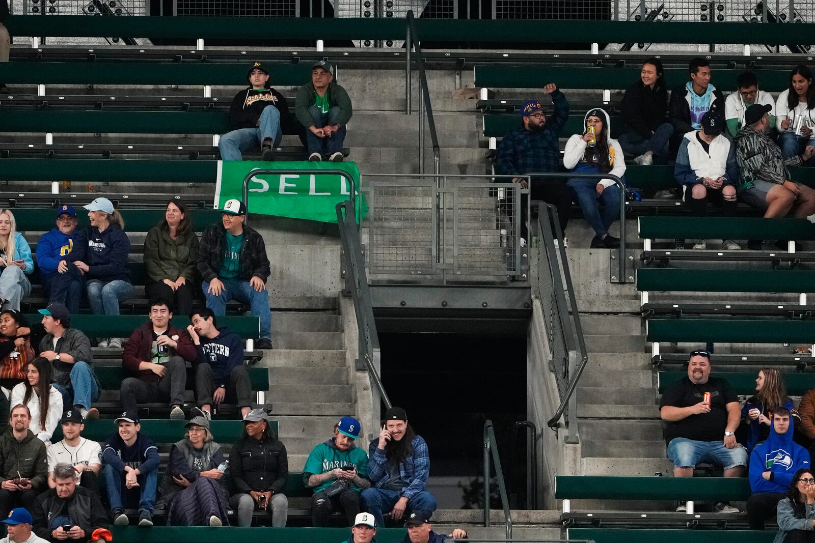 Fans sit near a "sell" flag during the eighth inning of a baseball game between the Seattle Mariners and the Oakland Athletics, Friday, Sept. 27, 2024, in Seattle. (AP Photo/Lindsey Wasson)