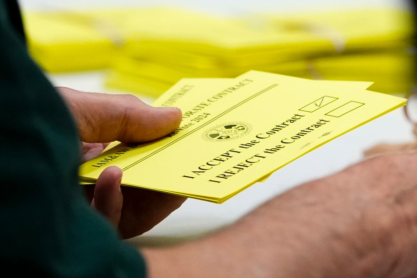 A volunteer holds a vote to accept a new contract offer from Boeing, Wednesday, Oct. 23, 2024, at Seattle Union Hall in Seattle. (AP Photo/Lindsey Wasson)