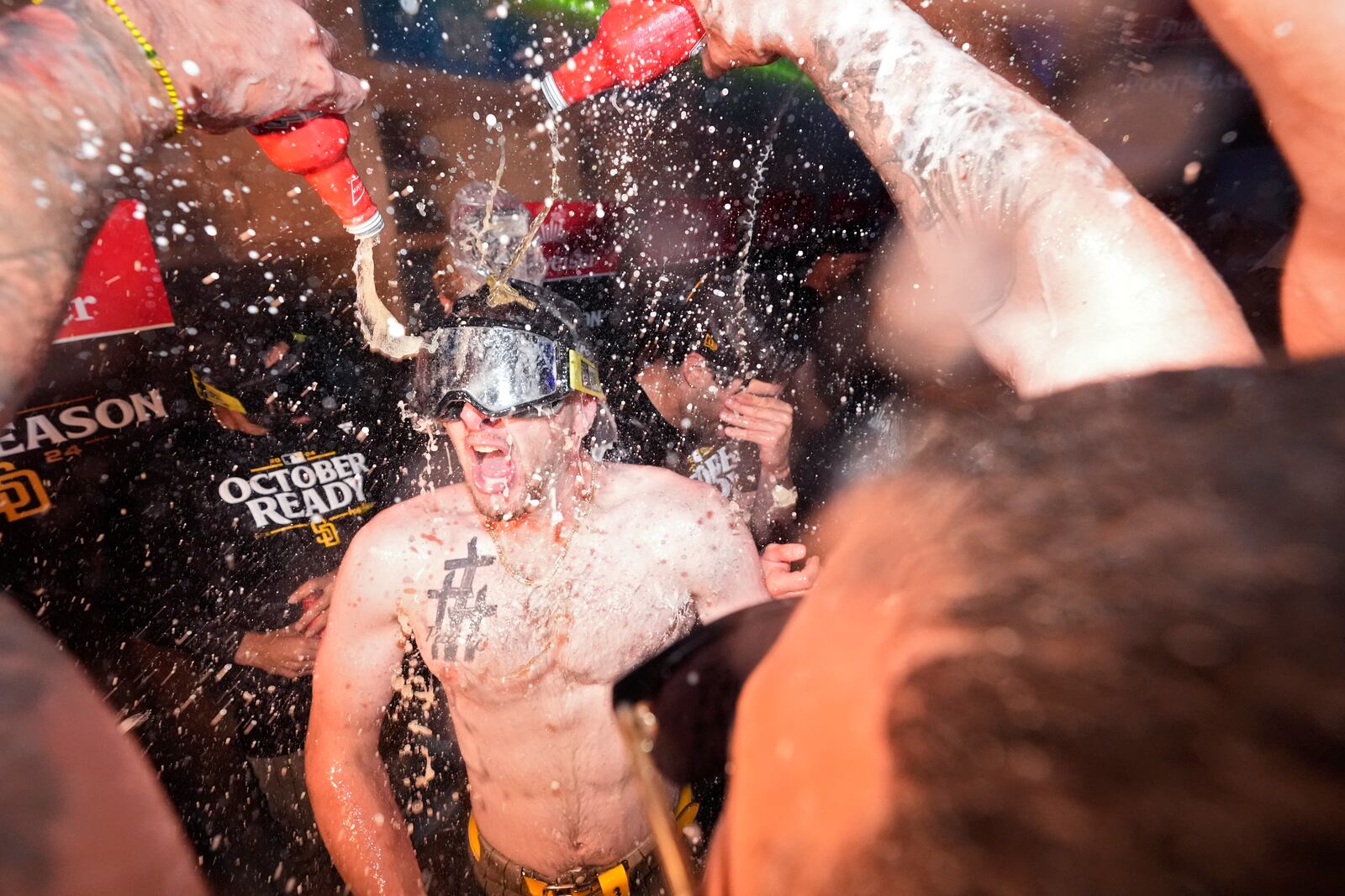 San Diego Padres' Jackson Merrill, center, celebrates with teammates after the Padres clinched a playoff spot with a triple play to end their baseball game against the Los Angeles Dodgers, Tuesday, Sept. 24, 2024, in Los Angeles. (AP Photo/Mark J. Terrill)