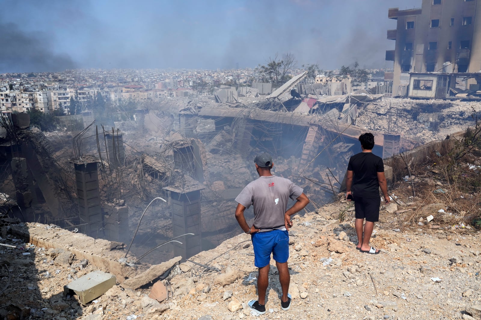 People check a damaged building at the site of an Israeli airstrike in Choueifat, south east of Beirut, Saturday, Sept. 28, 2024. (AP Photo/Hussein Malla)