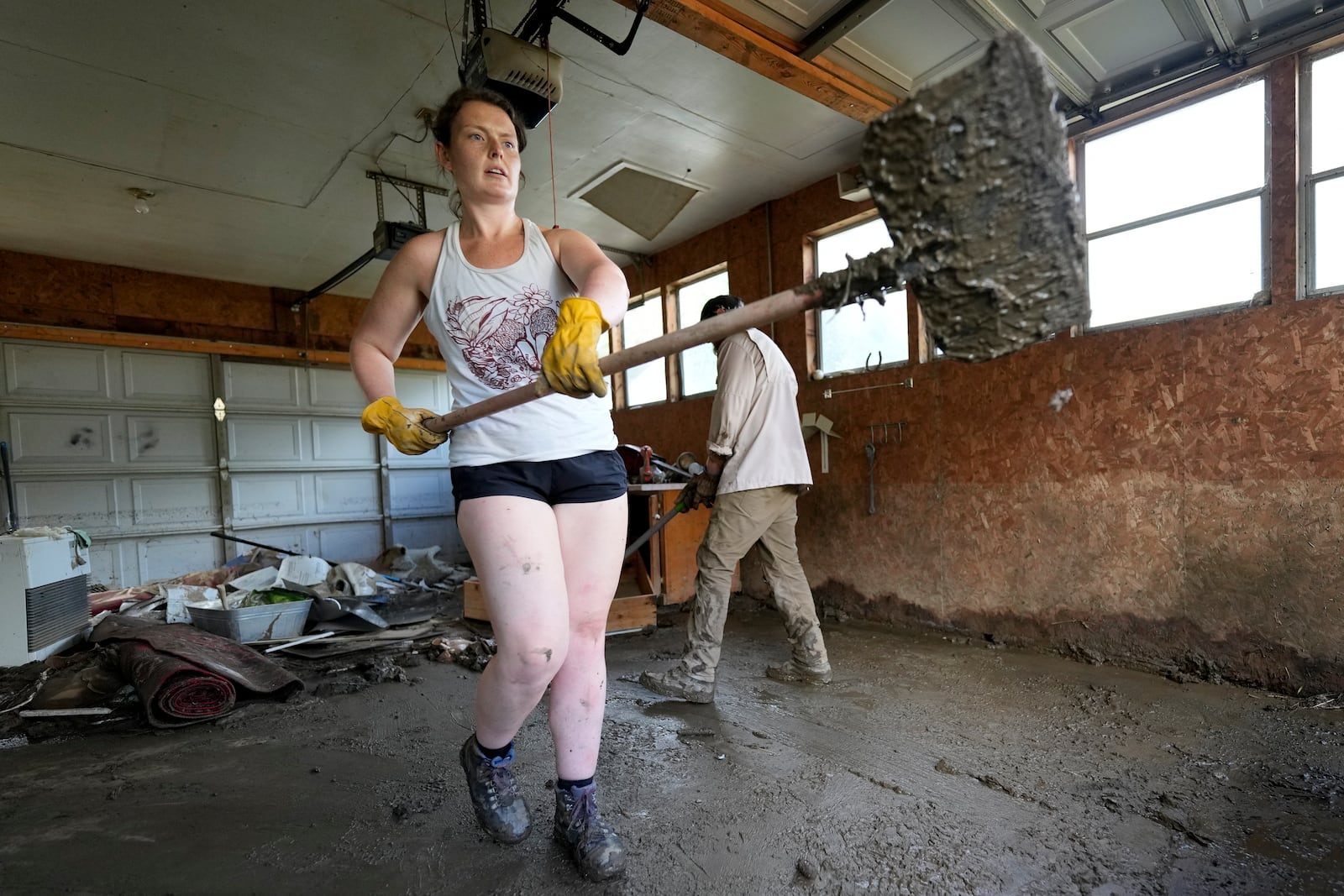 Stephanie Dixon and Grayson Jones clean up on Thursday, Oct. 3, 2024, in Vilas, N.C. in the aftermath of hurricane Helene. In the final weeks of the presidential election, people in North Carolina and Georgia, influential swing states, are dealing with more immediate concerns: recovering from Hurricane Helene. (AP Photo/Chris Carlson)