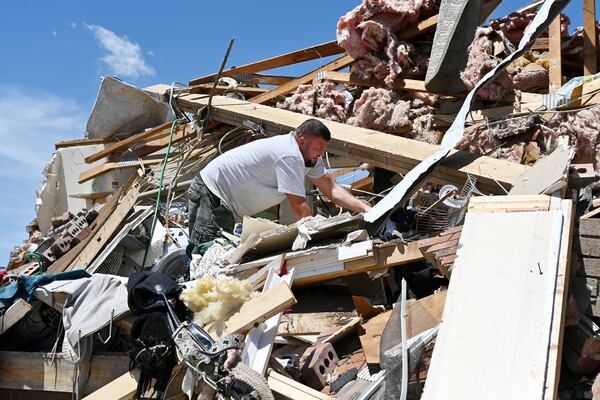 Anthony Broughton digs through the debris of his destroyed home following a severe storm in the Sunshine Hill neighborhood of London, Ky., Saturday, May 17, 2025. (AP Photo/Timothy D. Easley)