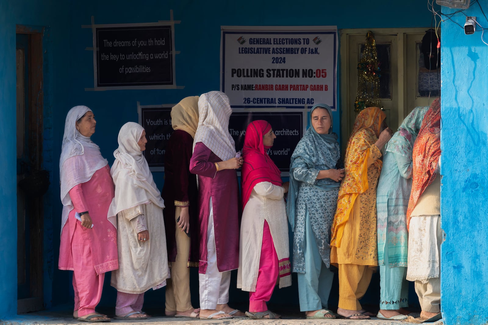 Kashmiri women queue up at a polling booth to cast their vote during the second phase of the assembly election in the outskirts of Srinagar, Indian controlled Kashmir, Wednesday, Sept. 25, 2024. (AP Photo/Dar Yasin)