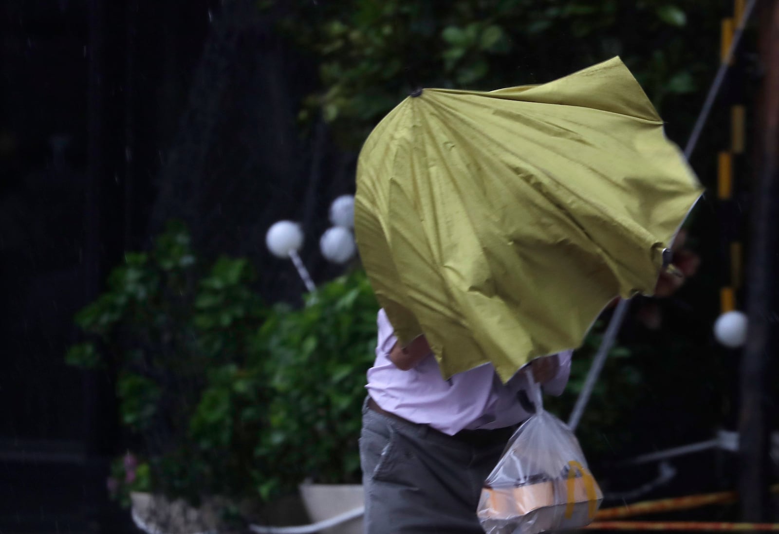 A man struggles with his umbrella against gusts of wind generated by Typhoon Kong-rey in Taipei, Taiwan, Thursday, Oct. 31, 2024. (AP Photo/Chiang Ying-ying)