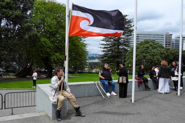 FILE - A protester against the Treaty Principles Bill sits outside Parliament in Wellington, New Zealand, Thursday, Nov. 14, 2024. (AP Photo/Charlotte Graham-McLay, File)