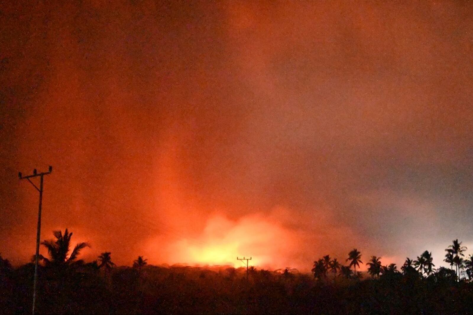 In this photo made available by Indonesia's Center for Volcanology and Geological Disaster Mitigation Agency (PVMBG) of the Ministry of Energy and Mineral Resources, the sky glows from the eruption of Mount Lewotobi Laki-Laki early Monday, Nov. 4, 2024, in East Flores, Indonesia. (PVMBG via AP)