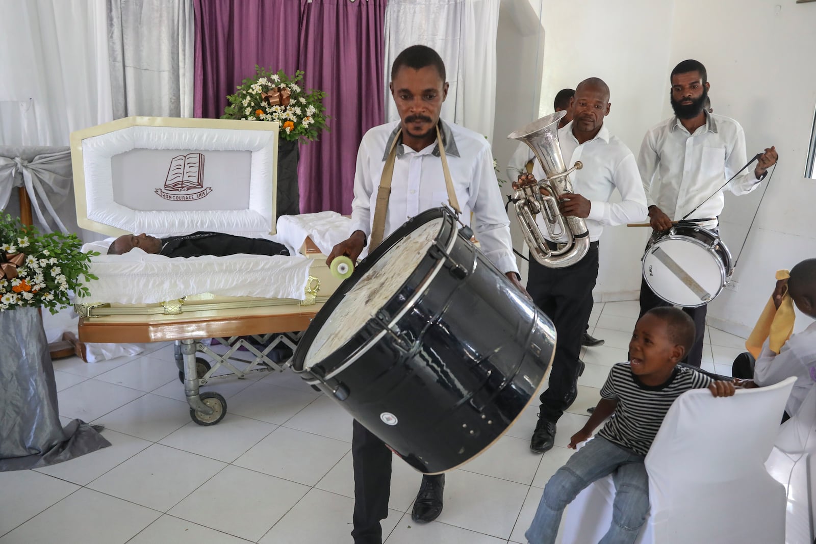 Musicians arrive at the funeral of Jean Louis Jeune Gracien, who was killed during an attack by armed gangs, in Pont-Sonde, Haiti, Tuesday, Oct. 8, 2024. (AP Photo/Odelyn Joseph)