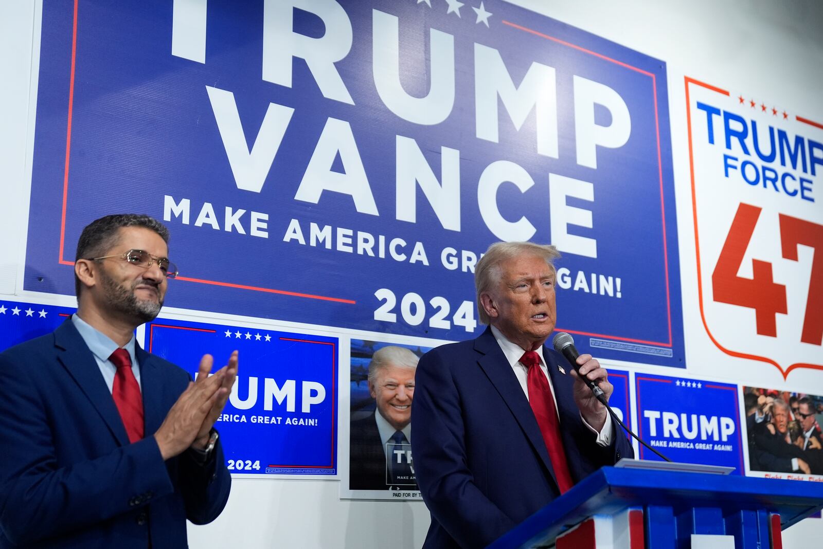 Republican presidential nominee former President Donald Trump speaks as Hamtranck Mayor Amer Ghalib listens at a campaign office, Friday, Oct. 18, 2024, in Hamtranck, Mich. (AP Photo/Evan Vucci)