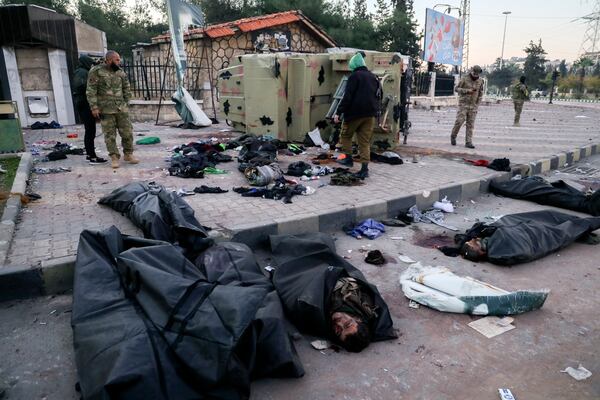 The bodies of Syrian army soldiers and allied fighters are collected by opposition fighters in body bags after being allegedly killed earlier in combat by opposition fighters in Aleppo, Syria, Saturday Nov. 30, 2024. Thousands of Syrian insurgents have fanned out inside Syria's largest city Aleppo a day after storming it with little resistance from government troops.(AP Photo/Omar Albam)