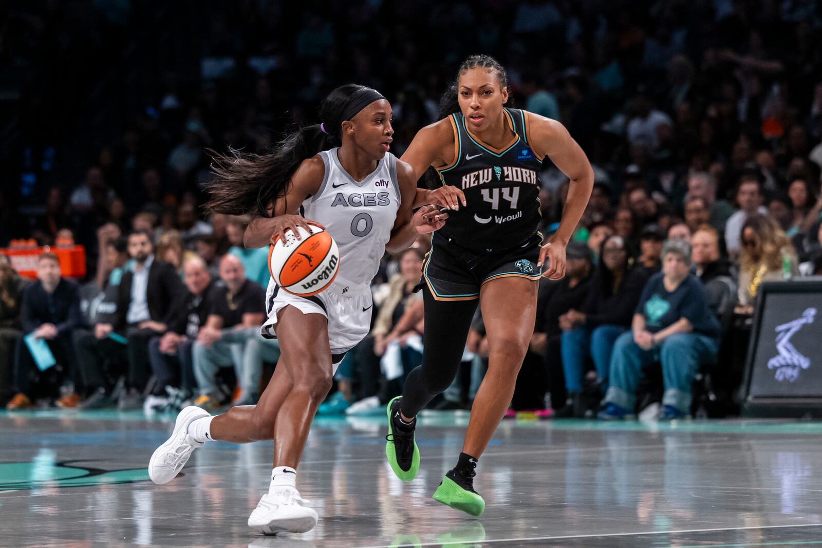 Las Vegas Aces guard Jackie Young (0) drives around New York Liberty forward Betnijah Laney-Hamilton (44) during the second half of a WNBA basketball second-round playoff game, Sunday, Sept. 29, 2024, in New York. (AP Photo/Corey Sipkin)