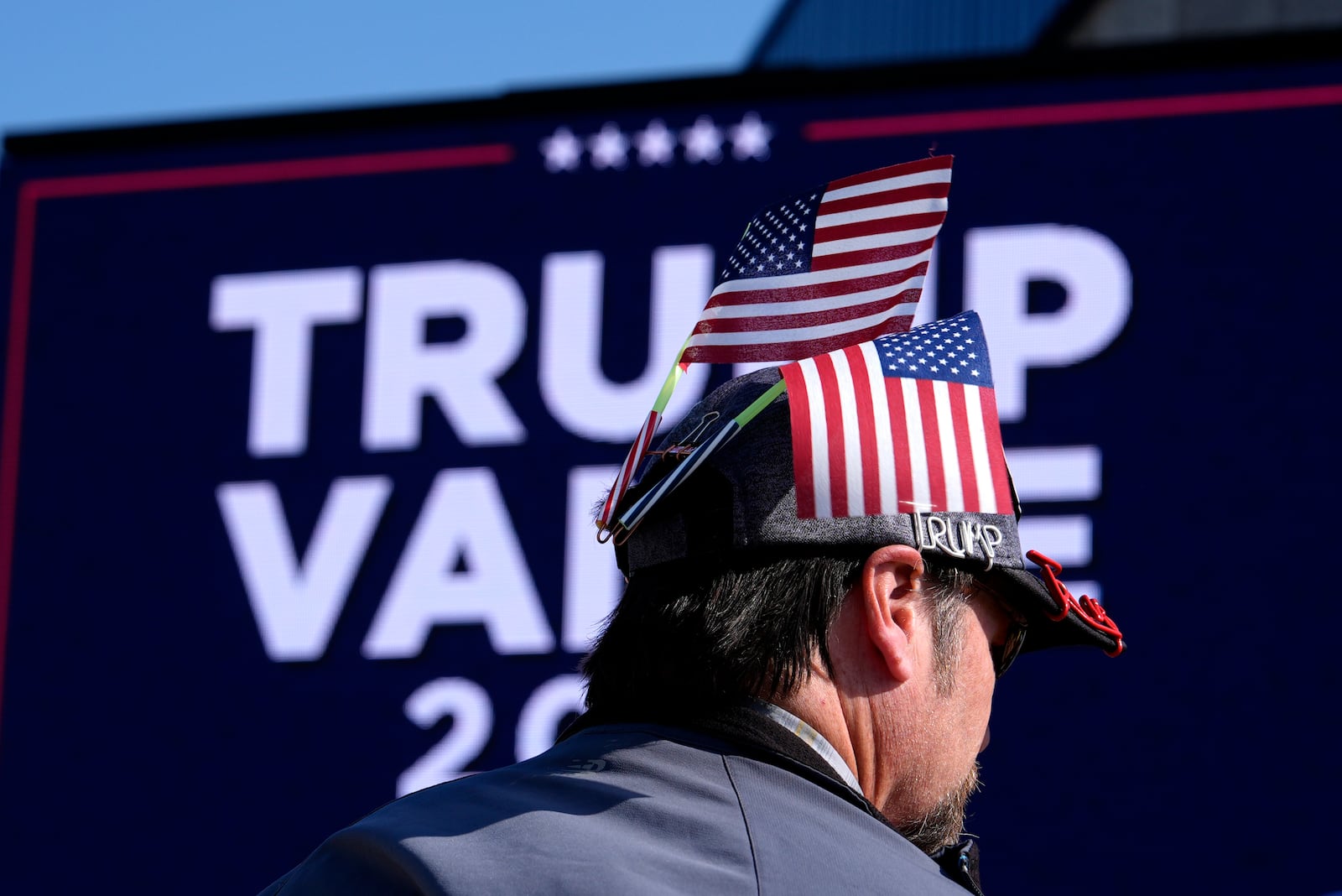 An attendee waits for Republican presidential nominee former President Donald Trump to speak during a campaign rally at Dodge County Airport, Sunday, Oct. 6, 2024, in Juneau, Wis. (AP Photo/Julia Demaree Nikhinson)