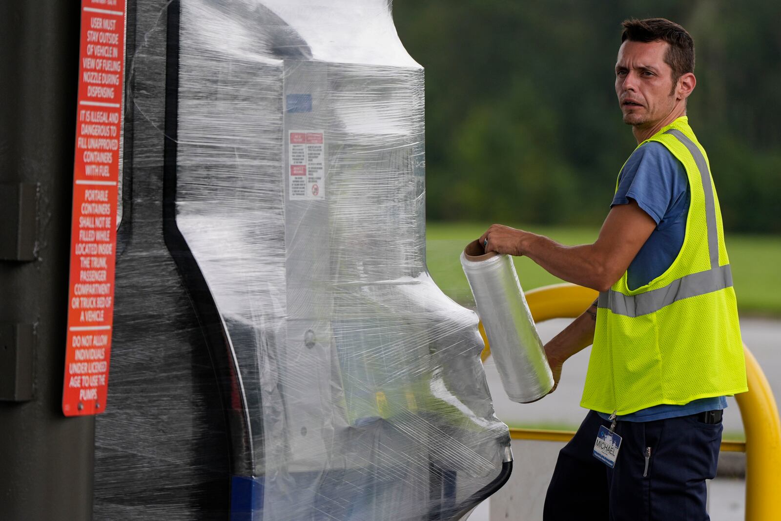 A Sam's Club employee wraps wraps fuel pumps ahead of Hurricane Helene, expected to make landfall Thursday evening, Thursday, Sept. 26, 2024, in Valdosta, Ga. (AP Photo/Mike Stewart)