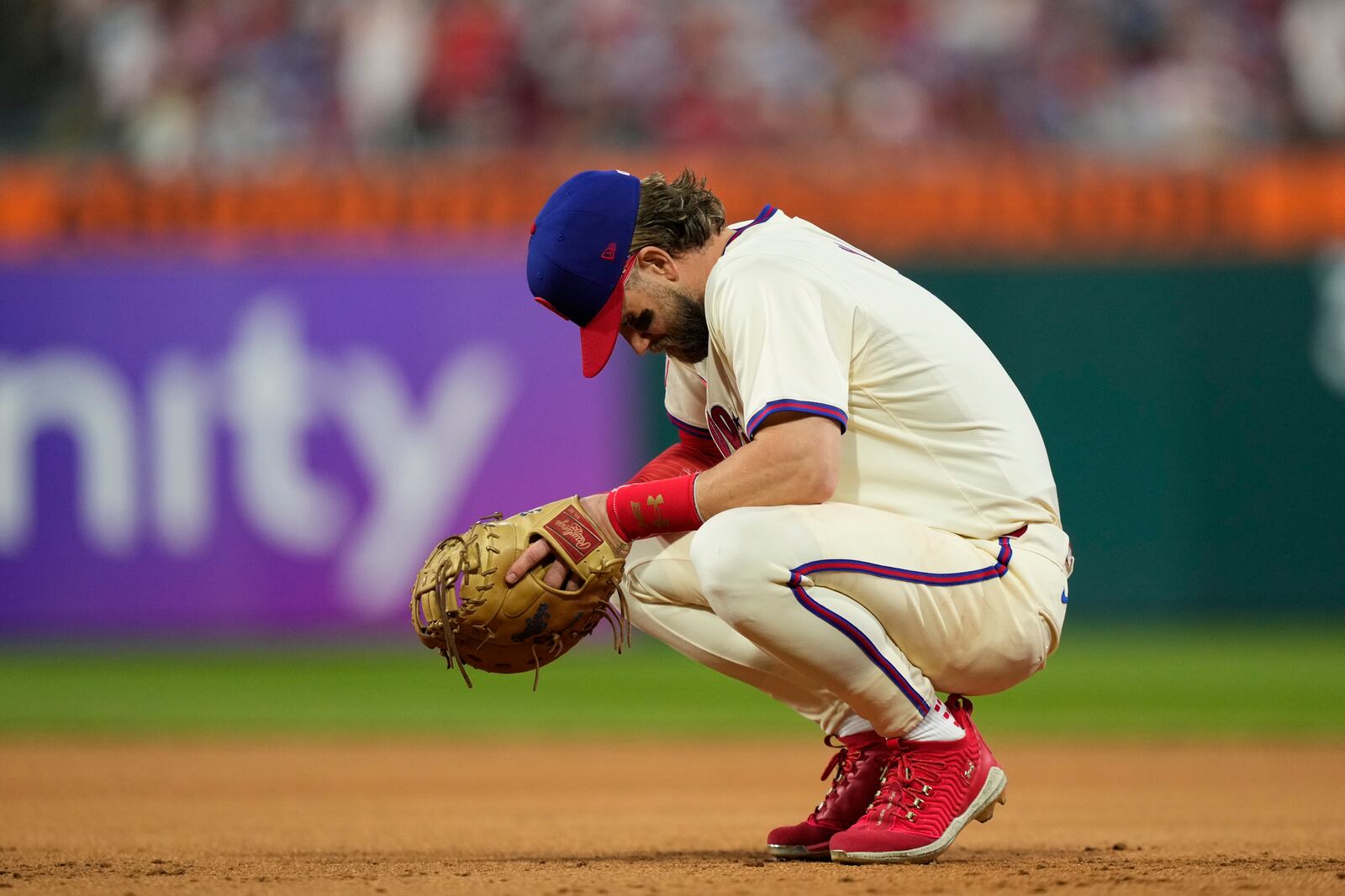 Philadelphia Phillies first base Bryce Harper rests during a pitching change during the eighth inning of Game 1 of a baseball NL Division Series against the New York Mets, Saturday, Oct. 5, 2024, in Philadelphia. (AP Photo/Matt Slocum)