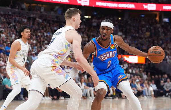 Oklahoma City Thunder guard Shai Gilgeous-Alexander, right, drives to the basket as Denver Nuggets guard Christian Braun defends in the second half of Game 6 in the Western Conference semifinals of the NBA basketball playoffs Thursday, May 15, 2025, in Denver. (AP Photo/David Zalubowski)