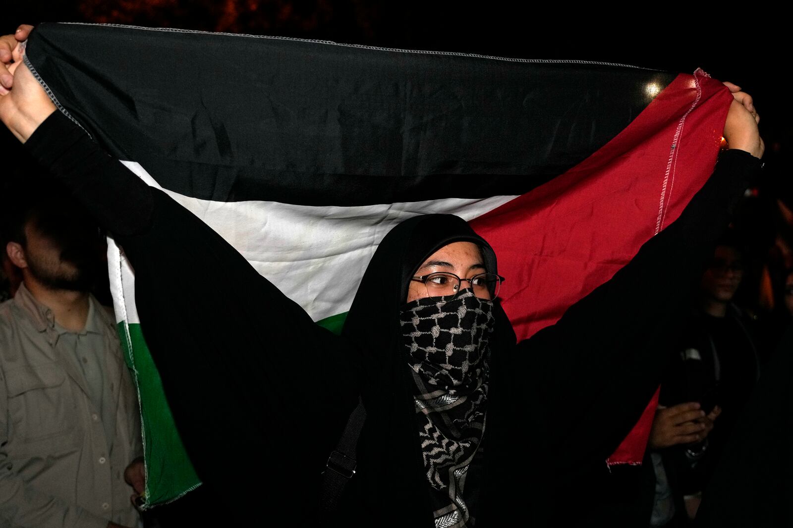 A demonstrator holds a Palestinian flag during an anti-Israeli gathering celebrating Iran's missile strike against Israel in front of the British Embassy in Tehran, Iran, Tuesday, Oct. 1, 2024. (AP Photo/Vahid Salemi)