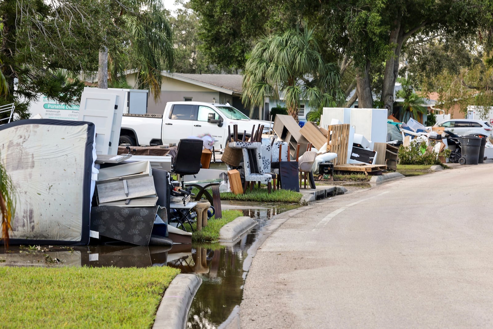 Residents discard items from their homes which filled with floodwaters from Hurricane Helene in the Shore Acres neighborhood on Saturday, Sept. 28, 2024, in St. Petersburg, Fla. (AP Photo/Mike Carlson)