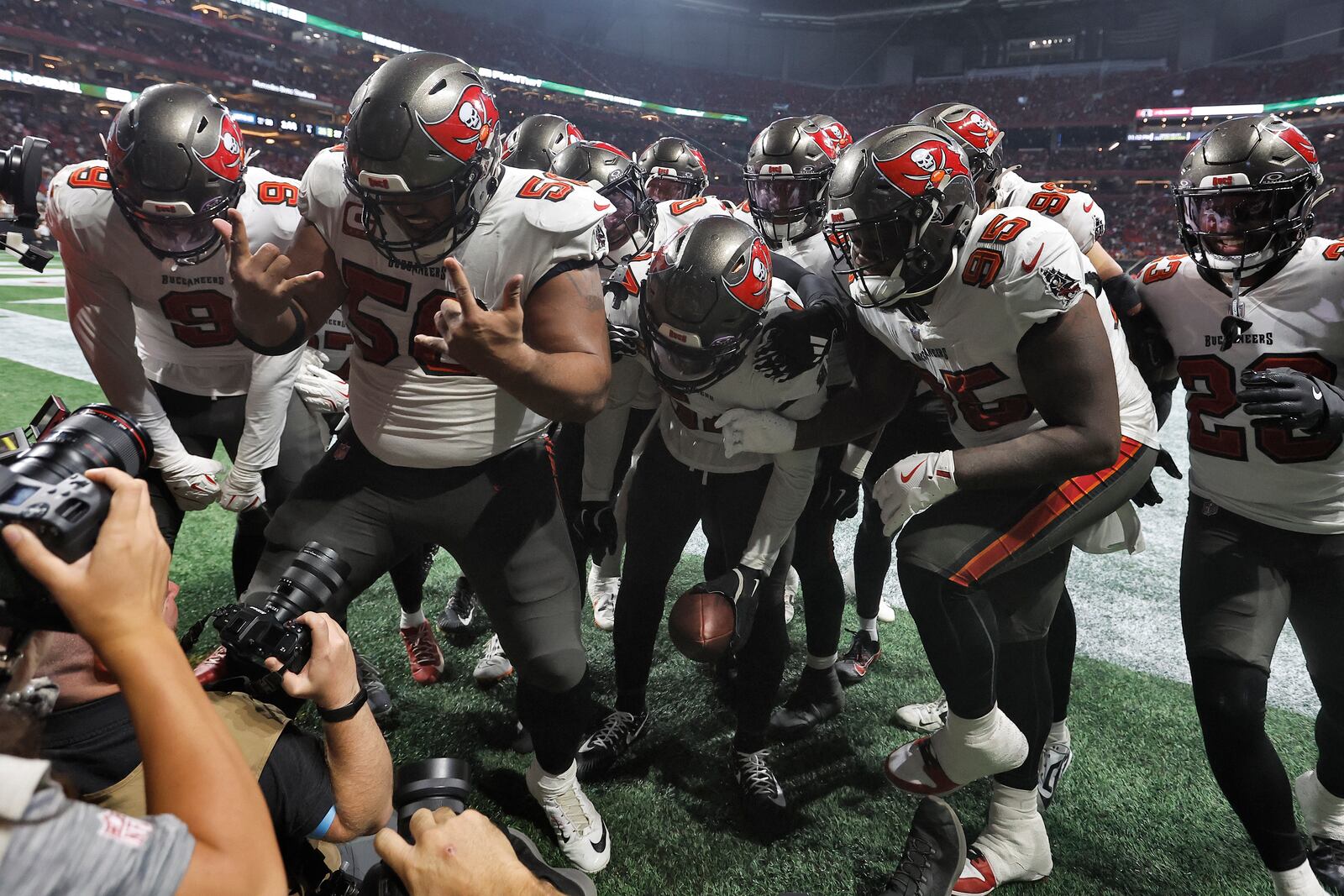 The Tampa Bay Buccaneers defense celebrates after linebacker Lavonte David, center, intercepted a pass by Atlanta Falcons quarterback Kirk Cousins during the second half of an NFL football game Thursday, Oct. 3, 2024, in Atlanta. (AP Photo/Butch Dill)