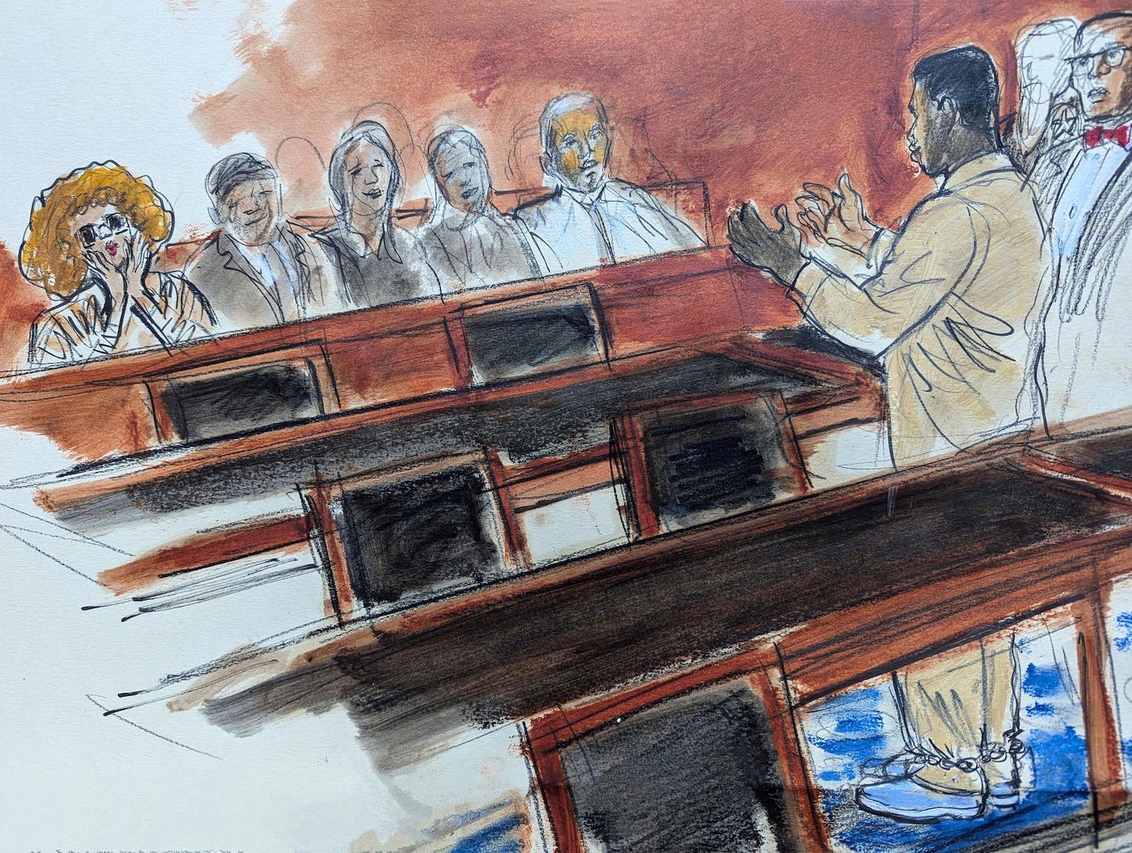 In this courtroom sketch, Sean "Diddy" Combs, right, in shackles, gestures to his mother, seated in the audience far left,,who is blowing kisses to him, following his hearing in federal court in New York, Thursday, Oct. 10, 2024. (Elizabeth Williams via AP)