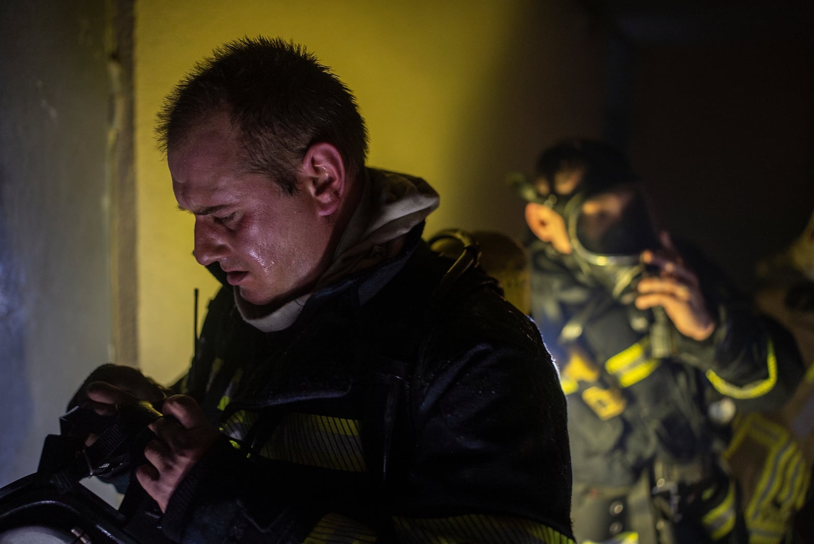 Firefighters wear oxygen masks before entering a floor that burned down after a Russian attack killed a teenager in Kyiv, Ukraine, Friday, Oct. 25, 2024. (AP Photo/Alex Babenko)