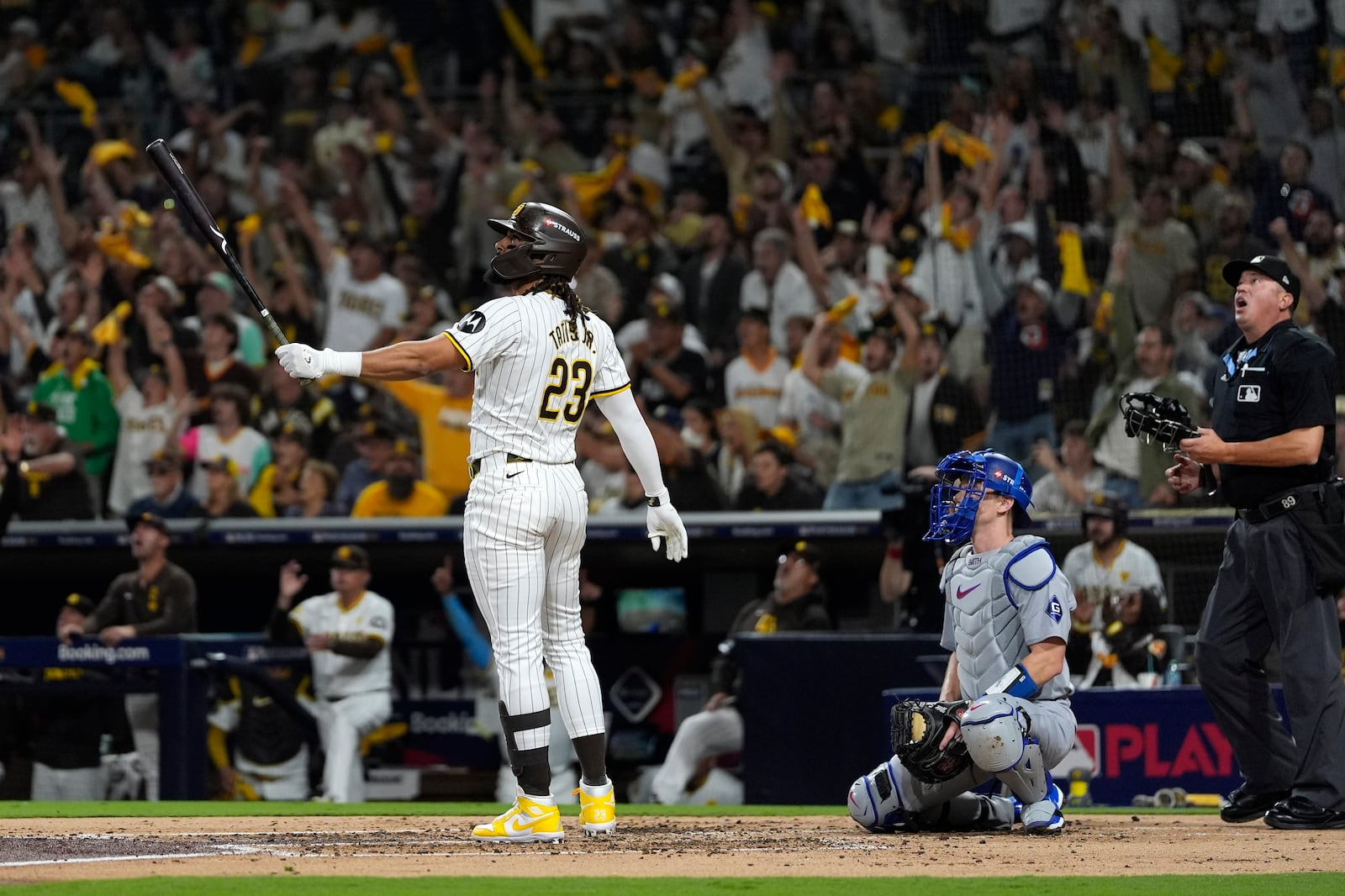 San Diego Padres' Fernando Tatis Jr., left, follows through on his two-run home run as Los Angeles Dodgers catcher Will Smith, center, and home plate umpire Cory Blaser watch during the second inning in Game 3 of a baseball NL Division Series, Tuesday, Oct. 8, 2024, in San Diego. (AP Photo/Gregory Bull)