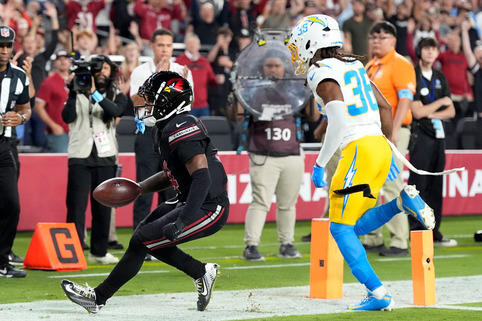 Arizona Cardinals wide receiver Greg Dortch catches a 5-yard touchdown pass in front of Los Angeles Chargers cornerback Ja'Sir Taylor (36) during the first half of an NFL football game, Monday, Oct. 21, 2024, in Glendale Ariz. (AP Photo/Ross D. Franklin)