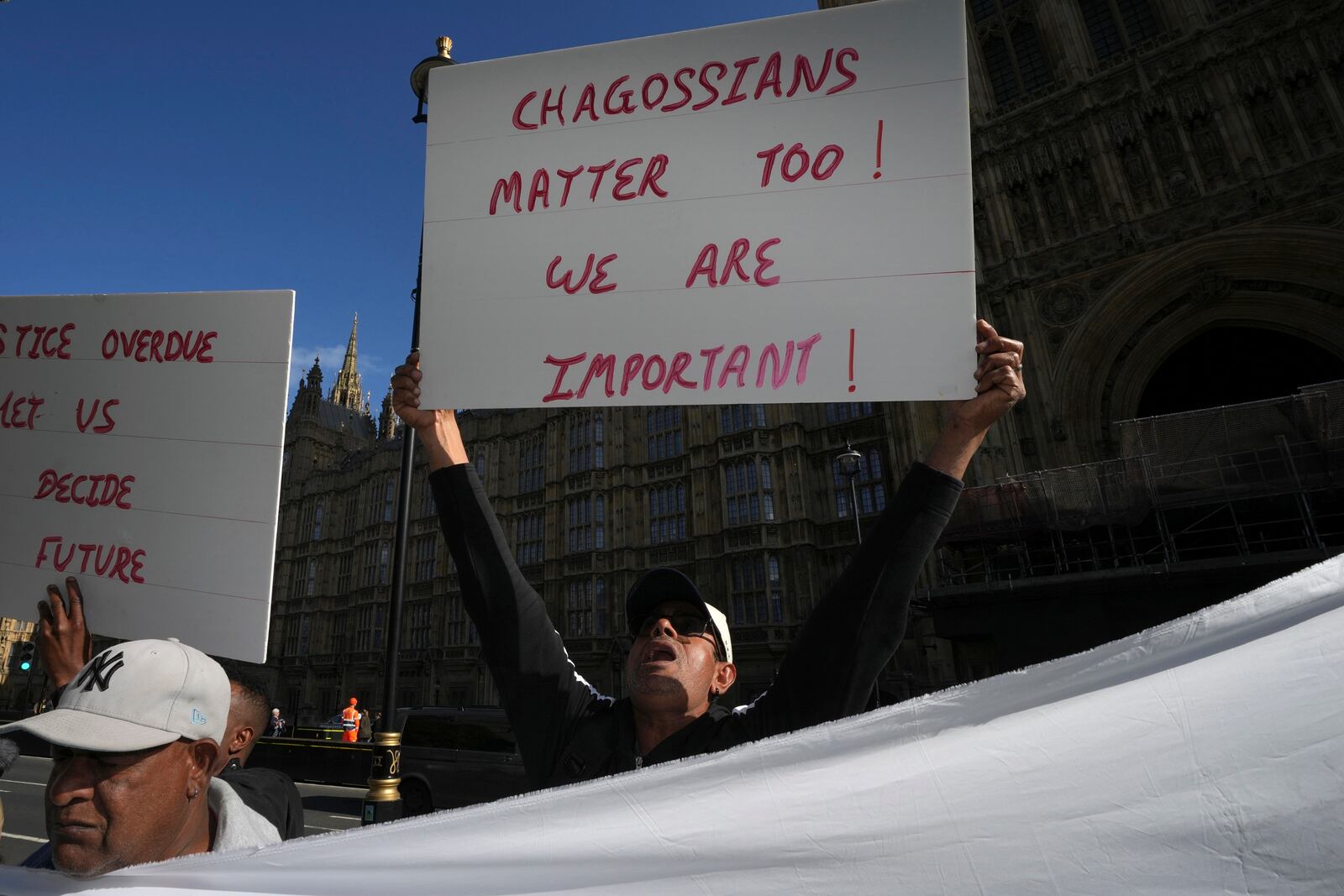 Chagossians attend a protest to response the U.K. announcement to agree to hand sovereignty of the long-contested Chagos Islands to Mauritius and against their "Exclusion" from Chagos negotiations, outside the House of Parliament, in London, Monday, Oct. 7, 2024. (AP Photo/Kin Cheung)