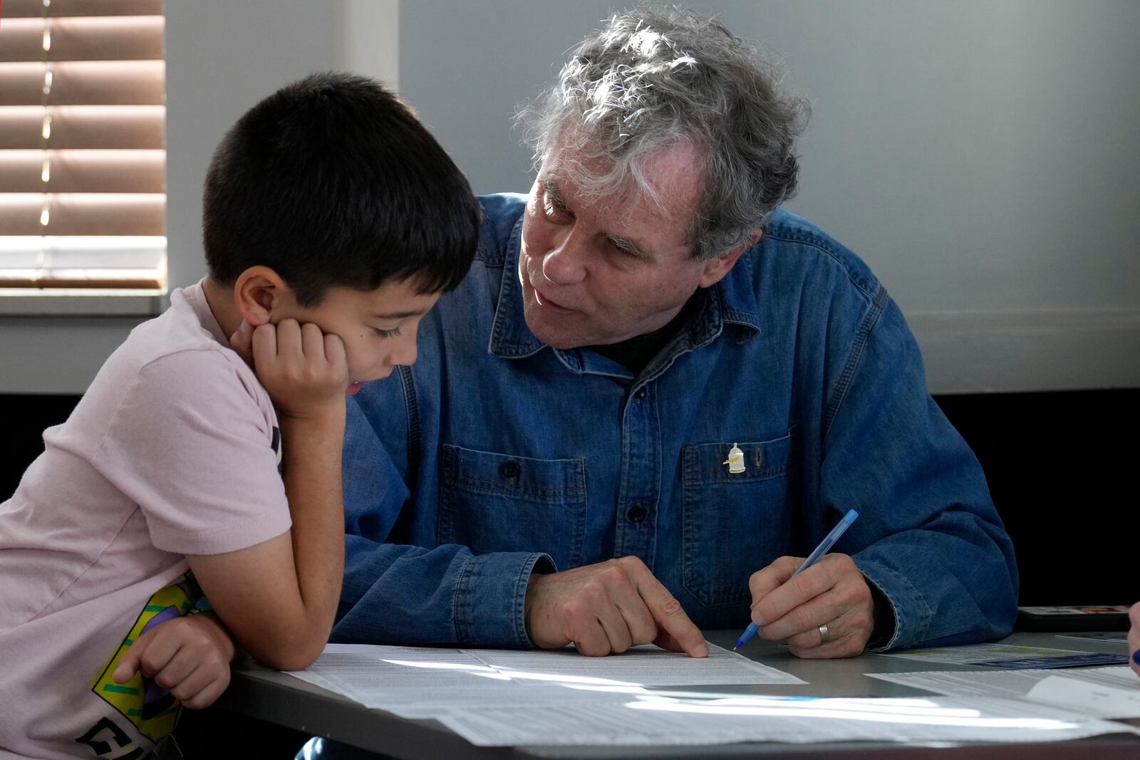 Sen. Sherrod Brown, D-Ohio, fills out his ballot with his grandson, Milo Molina, left, age eight, Tuesday, Nov. 5, 2024, in Cleveland. (AP Photo/Sue Ogrocki