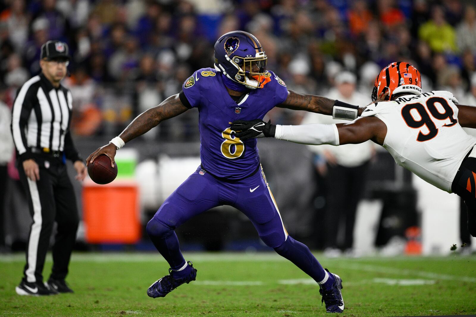 Baltimore Ravens quarterback Lamar Jackson (8) is pressures by Cincinnati Bengals defensive end Myles Murphy (99) during the second half of an NFL football game, Thursday, Nov. 7, 2024, in Baltimore. (AP Photo/Nick Wass)