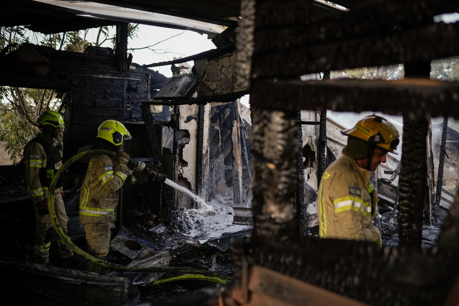 Israeli firefighters work at a house that was hit by a rocket fired from Lebanon, near the city of Safed, northern Israel, on Saturday, Sept. 21, 2024. (AP Photo//Leo Correa)