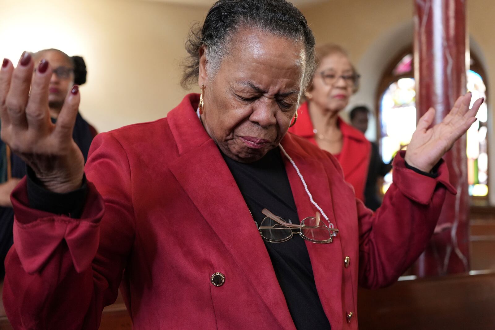 A congregant at Mother Bethel AME Church prays during a service in Philadelphia on Sunday, Oct. 13, 2024. (AP Photo/Luis Andres Henao)