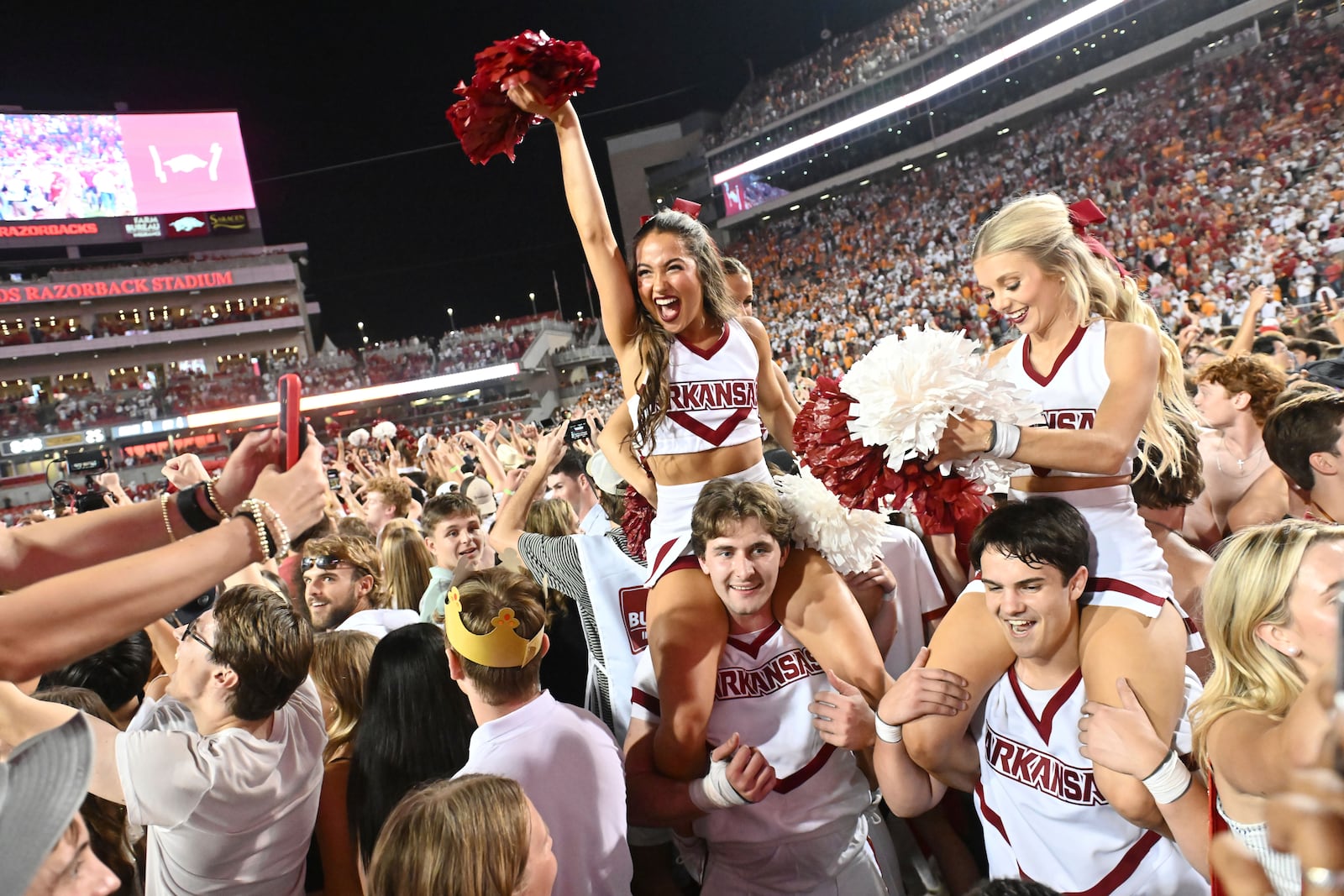 Arkansas cheerleaders and fans celebrate after Arkansas upsets Tennessee 19-14 during an NCAA college football game, Saturday, Oct. 5, 2024, in Fayetteville, Ark. (AP Photo/Michael Woods)