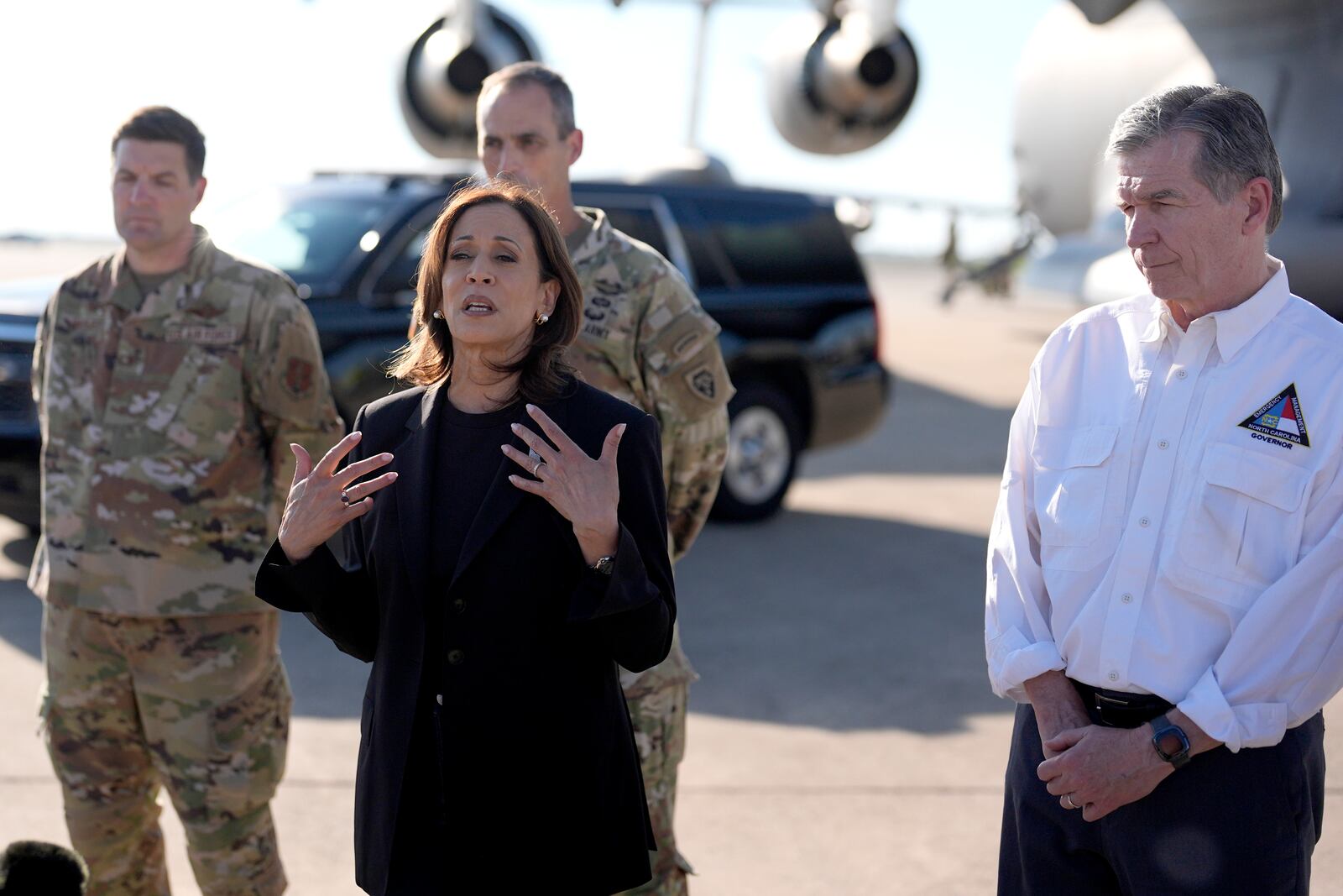 Democratic presidential nominee Vice President Kamala Harris speaks alongside North Carolina Gov. Roy Cooper, right, near a C-17 cargo plane after receiving a briefing on the damage from Hurricane Helene, Saturday, October 5, 2024, at the 145th Airlift Wing of the North Carolina Air National Guard in Charlotte, N.C. (AP Photo/Chris Carlson)