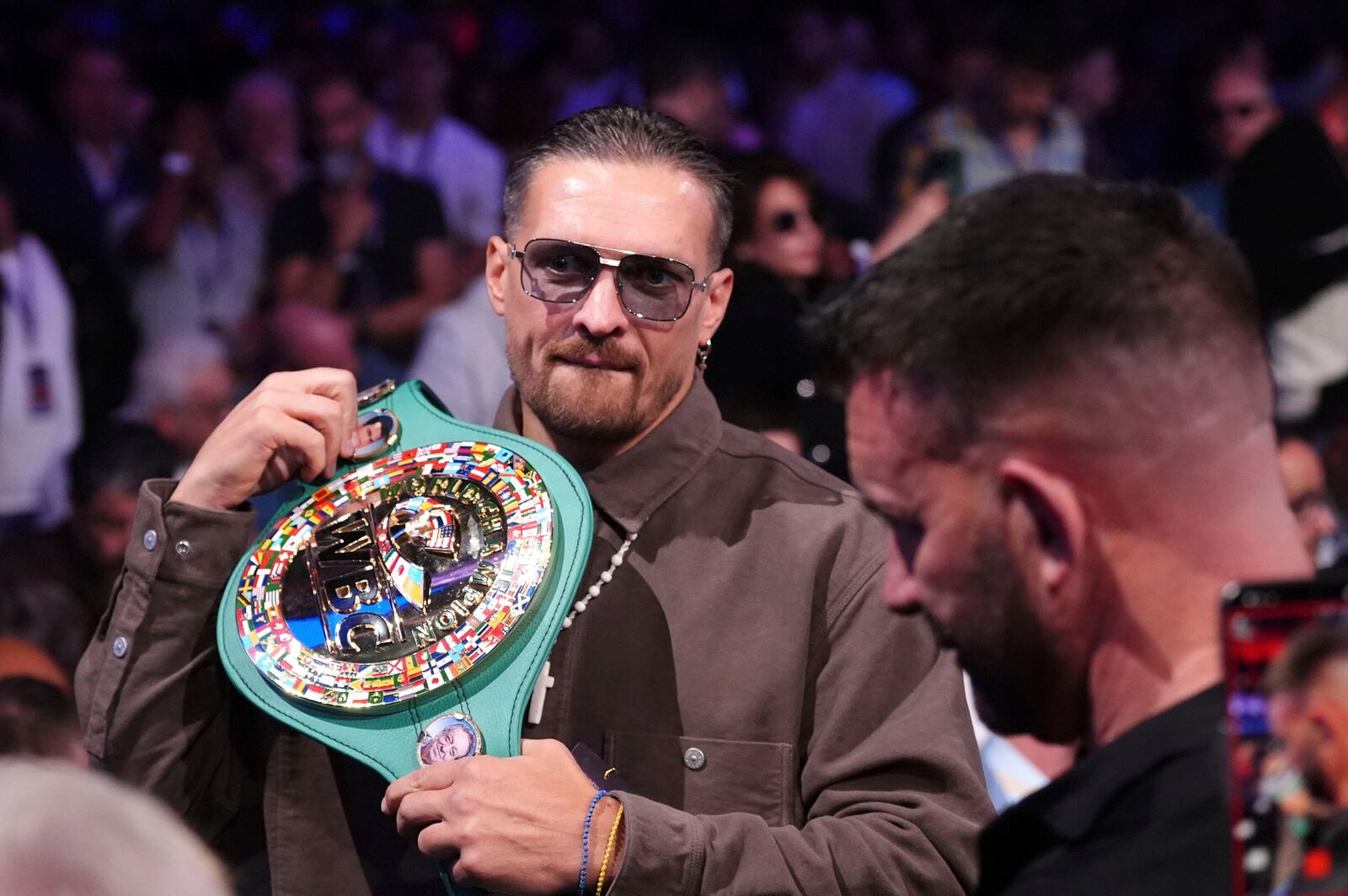 Ukrainian boxer Oleksandr Usyk in the stands with his belt at Wembley Stadium, in London, Saturday, Sept. 21, 2024. (Bradley Collyer/PA via AP)