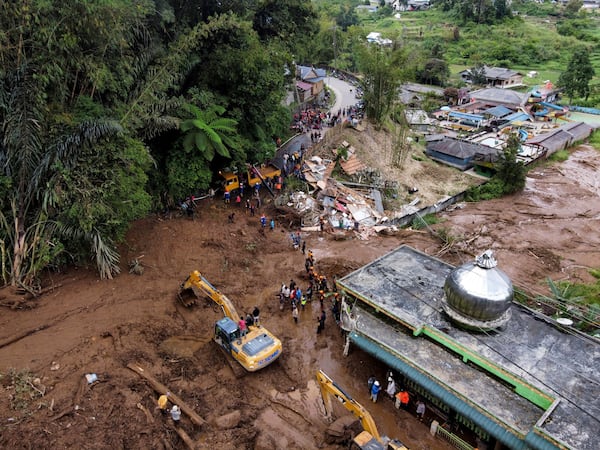 Rescuers use heavy machinery to search for victims after a landslide that killed a number of people and left some others missing in Karo, North Sumatra, Indonesia, Monday, Nov. 25, 2024. (AP Photo/Binsar Bakkara)