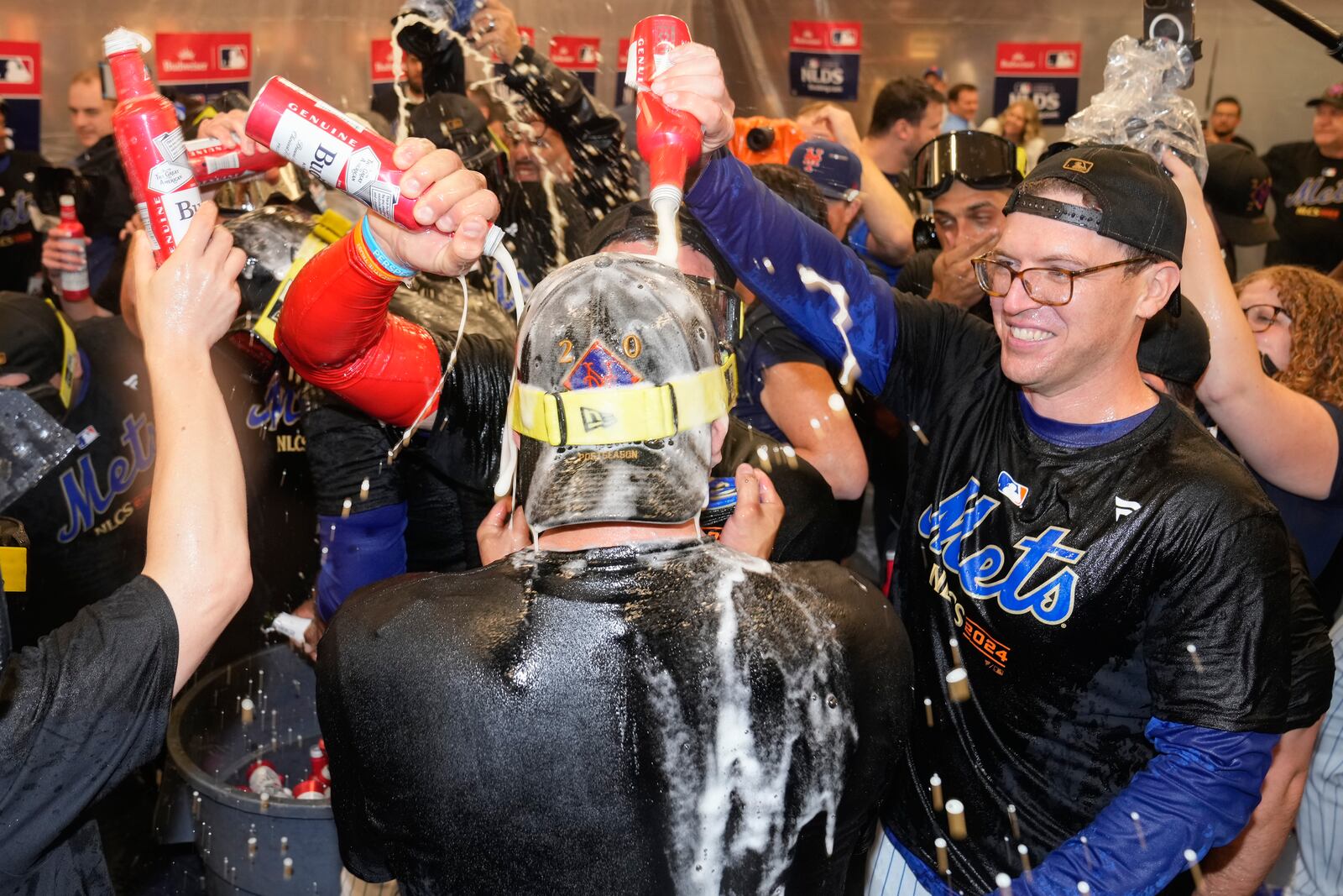 The New York Mets celebrate in the locker room after defeating the Philadelphia Phillies in Game 4 of the National League baseball playoff series, Wednesday, Oct. 9, 2024, in New York. (AP Photo/Frank Franklin II)