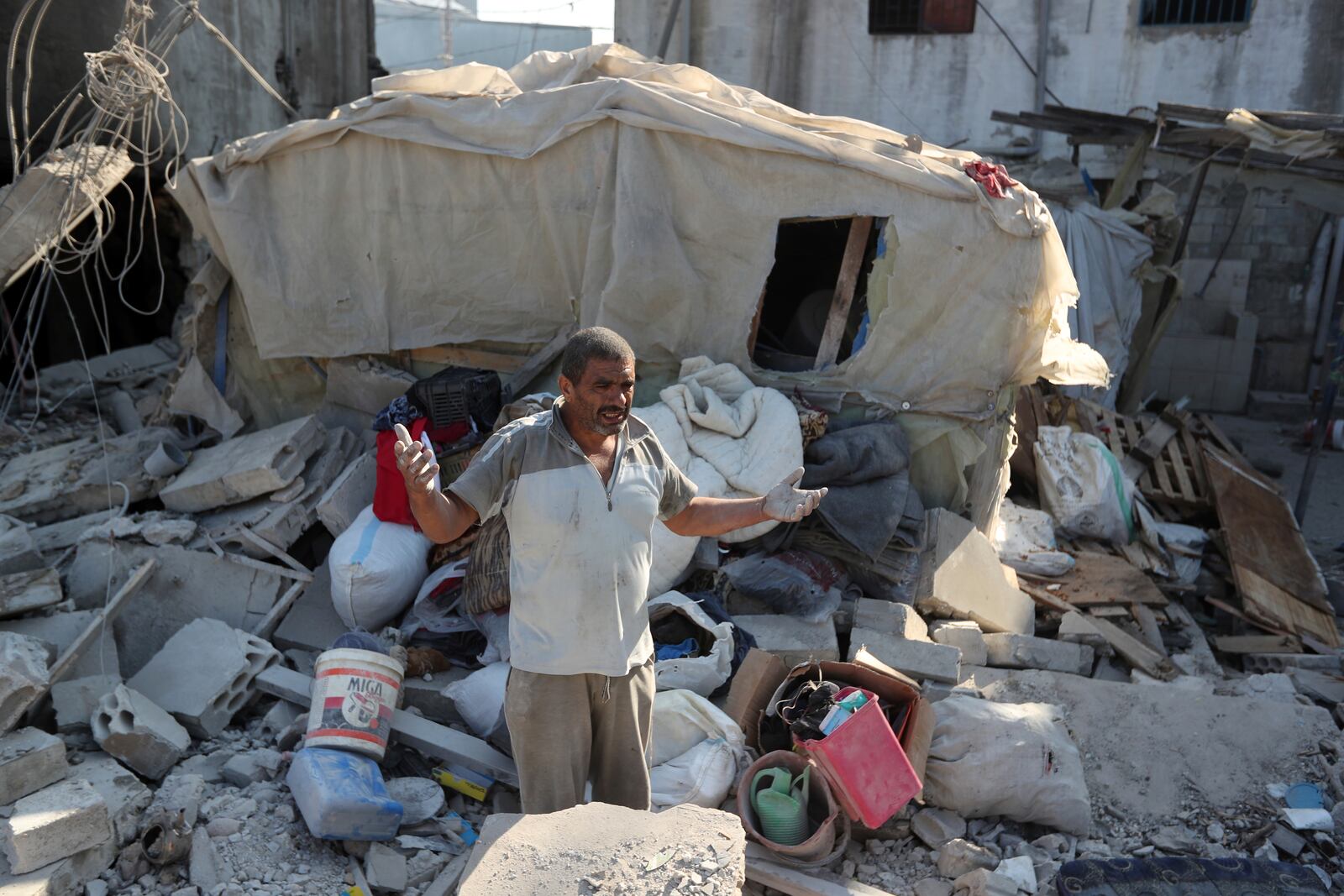 A man reacts as he stands on the rubble of a building hit in an Israeli airstrike in the southern village of Akbieh, Lebanon, Tuesday, Sept. 24, 2024. (AP Photo/Mohammed Zaatari)