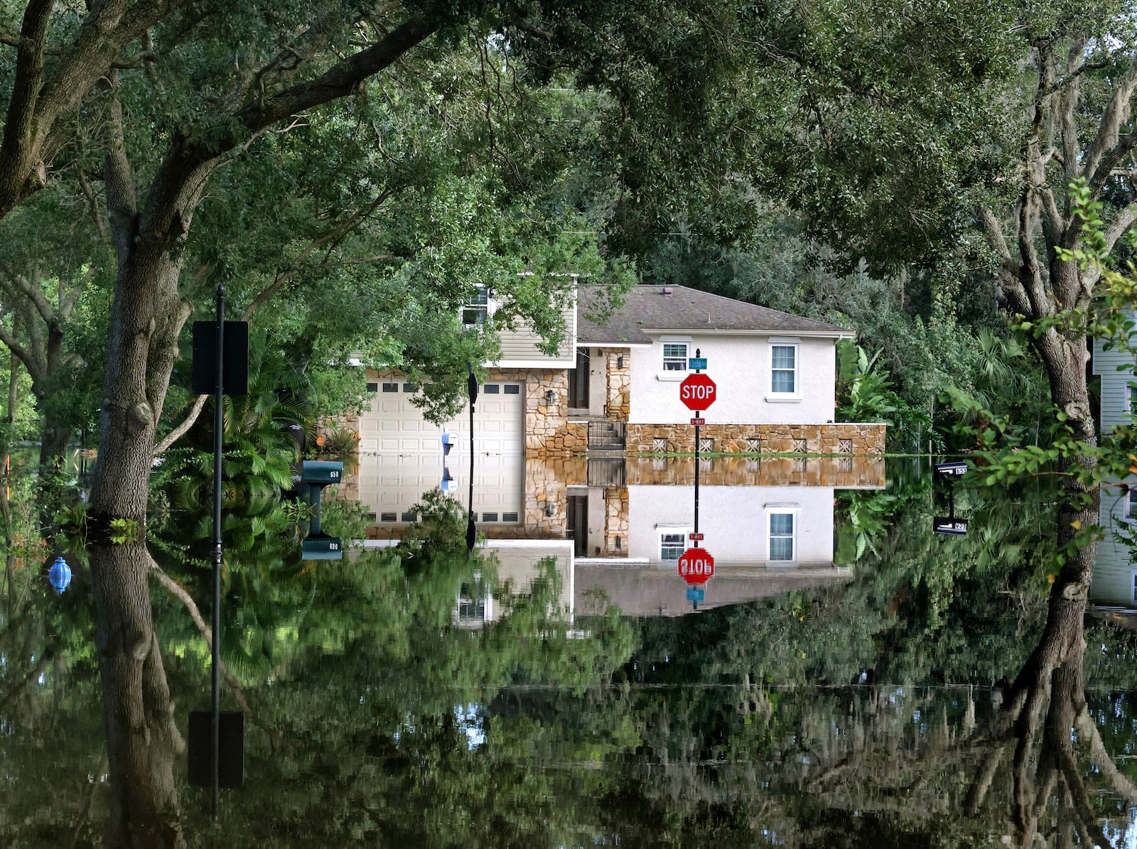 A home on Little Wekiva Road in the Spring Oaks neighborhood in Altamonte Springs, Fla is reflected in the floodwaters from the Little Wekiva River, Friday, Oct. 11, 2024. Central Florida rivers are forecast to crest in the coming days because of the excessive rainfall from Hurricane Milton. (Joe Burbank/Orlando Sentinel via AP)