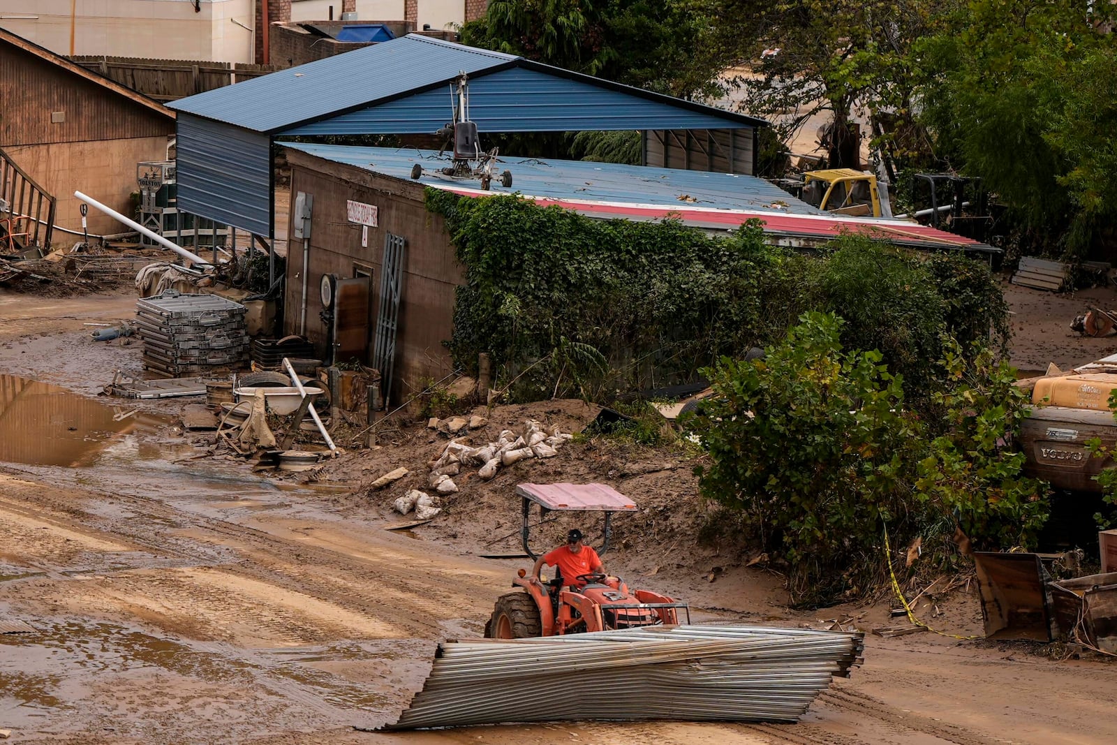 A worker moves debris in the aftermath of Hurricane Helene, Monday, Sept. 30, 2024, in Ashville, N.C. (AP Photo/Mike Stewart)