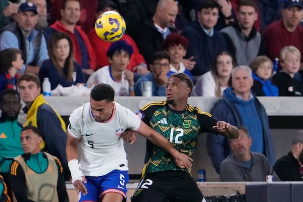 Jamaica's Tayvon Gray (12) and United States' Ricardo Pepi (9) battle for the ball during the first half in a CONCACAF Nations League quarterfinal second leg soccer match Monday, Nov. 18, 2024, in St. Louis. (AP Photo/Jeff Roberson)