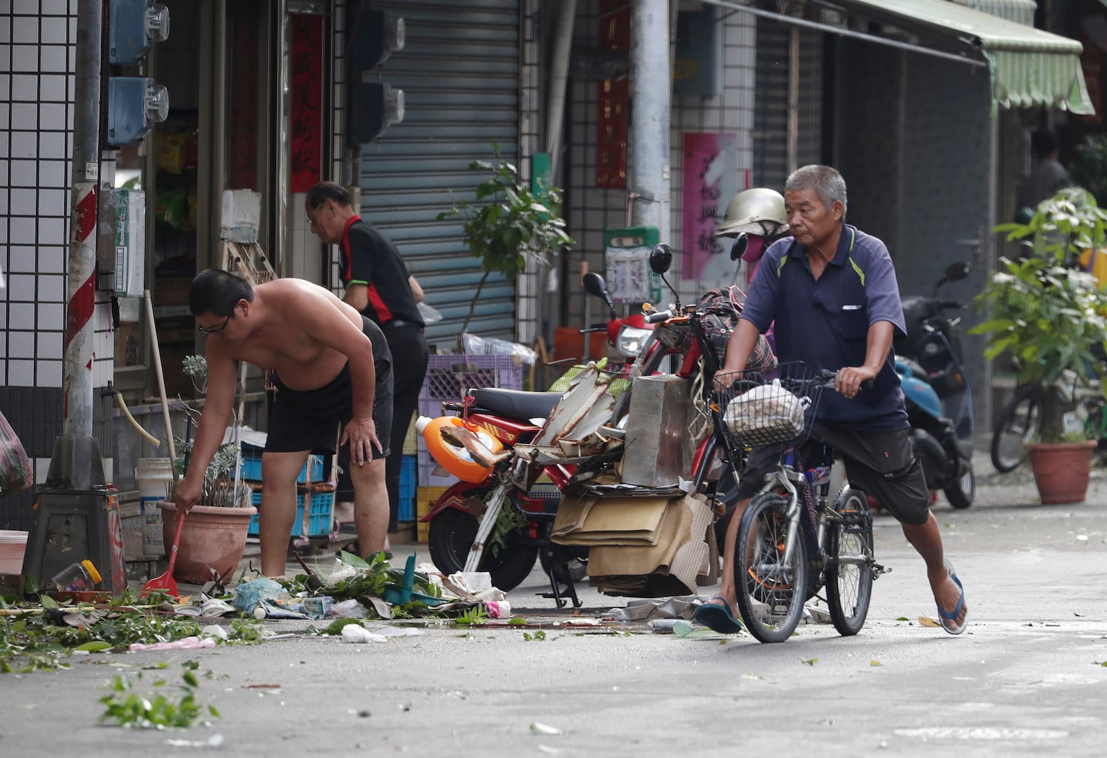 People clear debris in the aftermath of Typhoon Krathon in Kaohsiung, southern Taiwan, Friday, Oct. 4, 2024. (AP Photo/Chiang Ying-ying)